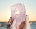 Woman`s hand holding gem grade rough Rose Quartz chunk from Madagascar Royalty Free Stock Photo