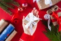 Woman`s hand holding gift box with white bow. Close-up. Top view. Christmas, New Year, Valentine`s day and birthday concept. Royalty Free Stock Photo