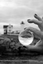 Woman`s hand holding glass ball with reflection of Nubble Lighthouse in the center, York, Maine, Fall, 2020