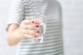 Woman`s of hand holding a glass of water on white background Royalty Free Stock Photo