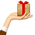 Woman`s hand holding gold gift box with red ribbon isolated on w Royalty Free Stock Photo