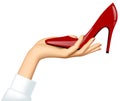 Woman`s hand holding a high-heeled red shoe isolated on white ba Royalty Free Stock Photo