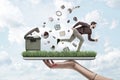Woman`s hand holding ipad with green grass growing on screen and man running from things flying out of trash can that is