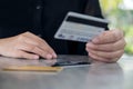 A woman`s hand holding and looking at credit cards on the table Royalty Free Stock Photo