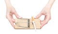 Woman`s hand holding mousetrap with cigarette on white background Royalty Free Stock Photo