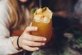 Woman`s hand holding old fashioned glass with cold cocktail against blurred night club background. Royalty Free Stock Photo