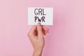 Woman`s hand holding a paper with text GRL PWR