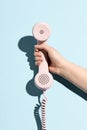 Woman`s hand holding a pastel telephone Royalty Free Stock Photo