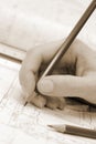 Woman`s palm holding pencil and architectural plans