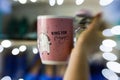 Woman`s hand holding a pink mug with motivational quote