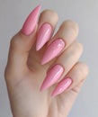 woman& x27;s hand holding pink nails