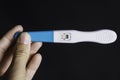 Woman`s hand holding a positive pregnancy test