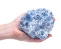 Woman`s hand holding raw blue calcite cluster