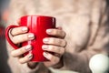 Woman`s hand holding a red cup of coffee. With a beautiful winter manicure. Drink, fashion, morning Royalty Free Stock Photo