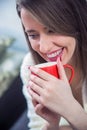 Woman`s hand holding a red cup of coffee. With a beautiful winter manicure. Royalty Free Stock Photo