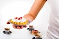 Woman`s hand holding small cake on beautiful set plate Royalty Free Stock Photo