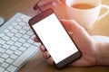 Woman`s hand holding smartphone on desk