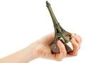 Woman's hand holding statuette of Eiffel Tower