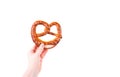 Woman`s hand holding traditional Bavarian salty pretzel