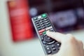 Woman`s hand is holding a TV remote control with streaming media services. Royalty Free Stock Photo