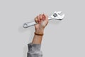 Woman's hand holding a wrench on an isolated white background Royalty Free Stock Photo