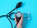 A woman`s hand holds a blood pressure monitor that shows blood pressure