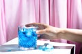 A woman`s hand holds a blue curacao cocktail with ice