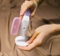 A woman`s hand holds a bottle of micellar water, a tonic cosmetic product with a cotton pad on a beige background Royalty Free Stock Photo