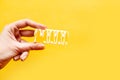 Woman `s hand holds a cake over yellow background Royalty Free Stock Photo
