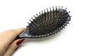 A woman`s hand holds a comb with a lot of hair on it. Concept of Hair Loss, Alopecia, Baldness Royalty Free Stock Photo