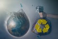 A woman`s hand holds a garbage bag next to the globe of planet Earth. Concept of ecology and environmental protection. The recycl Royalty Free Stock Photo