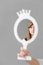 Reflection of a woman's face in the mirror on a light background