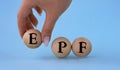 A woman's hand holds a wooden ball with the abbreviation EPF Royalty Free Stock Photo