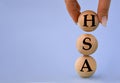 A woman\'s hand holds a wooden ball with the abbreviation HSA Royalty Free Stock Photo