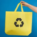 Woman`s hand holds a yellow viscose ecology bag