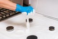 Woman`s hand in a household glove washing sponge with foam a gas stove and burners on the kitchen, close up Royalty Free Stock Photo