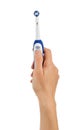 Woman`s hand includes on button of electric toothbrush isolated on white Royalty Free Stock Photo