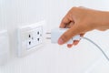 Woman`s Hand Inserting Electrical Power Cord Plug into Receptacle on wall outlet Royalty Free Stock Photo