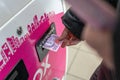 A woman`s hand is inserting money into the bill acceptor of the IBox payment terminal. Banknote of 200 Ukrainian hryvnias. Ukrain