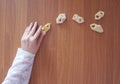 Woman`s hand in a lace blouse with small cookies. Elegant concept on wooden background with an empty space for text. The theme of Royalty Free Stock Photo