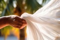 woman's hand with a light fabric in the wind against the backdrop of the nature.