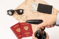 A woman`s hand opens a bottle of red wine with a corkscrew, a map of the world, two passports, money in a black leather wallet an Royalty Free Stock Photo