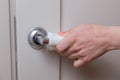 Woman`s hand opens the door and holds on to the door handle through a napkin. Phobia get infected with a virus