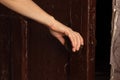 Woman`s hand opens the old dark door to the bedroom close up Royalty Free Stock Photo