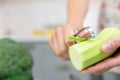 Woman`s hand peeling green fresh zucchini. Woman preparing delicious and healthy food in the home kitchen. Healthy diet concept Royalty Free Stock Photo