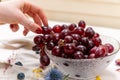 Woman`s hand picking one red grape on a crystal bowl Royalty Free Stock Photo