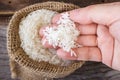 Woman's hand picking uncooked rice in a small burlap sack. Royalty Free Stock Photo