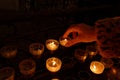 woman\'s hand places a sacrificial candle in a church