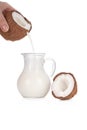 Woman's hand pouring coconut milk into a jar isolated on white Royalty Free Stock Photo