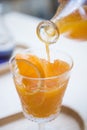 Woman's hand pouring orange juice into a glass Royalty Free Stock Photo
